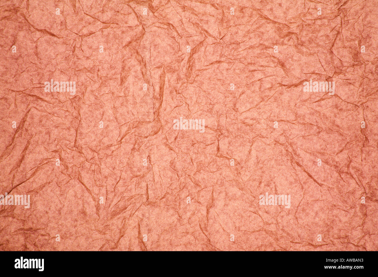 ABSTRACT RANDOM BACKGROUND OF CREASED CRUMPLED PALE RED TISSUE PAPER Stock Photo