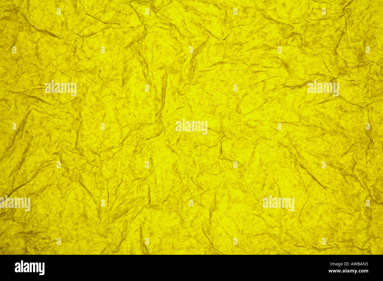 ABSTRACT RANDOM BACKGROUND OF CREASED CRUMPLED YELLOW TISSUE PAPER Stock Photo