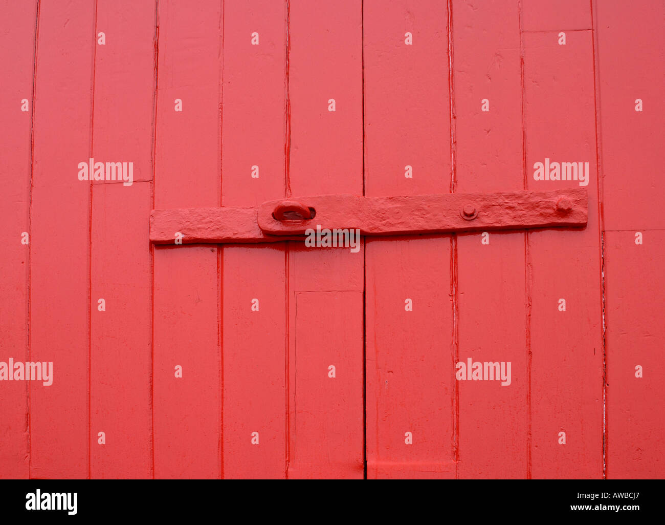 Red hasp and staple of the lock on the red door to the old lifeboat station Stock Photo