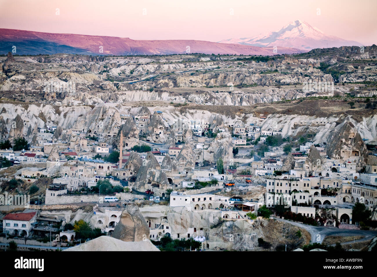 Overview of Goreme The white houses of Goreme fill the valley while snow covered Mount Erciyes shines with the setting sun Stock Photo