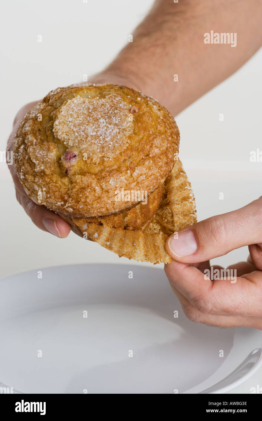 Hand peeling paper liner from muffin Stock Photo Alamy