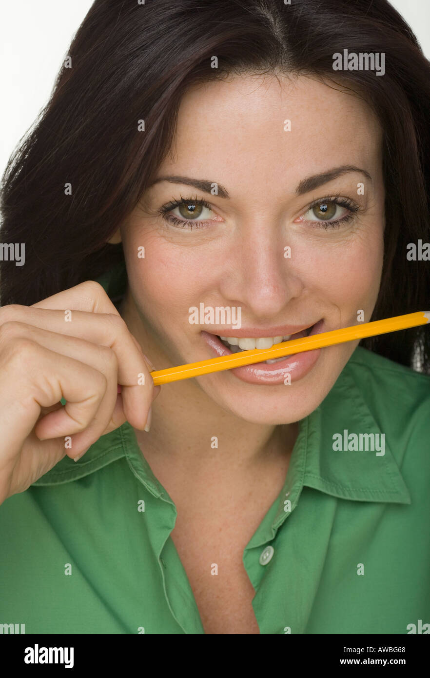 Portrait of woman with yellow pencil between teeth Stock Photo