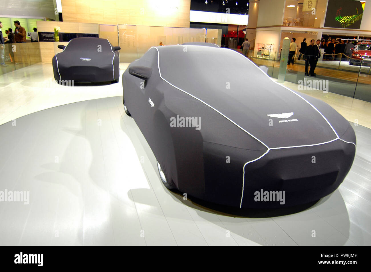 Aston Martin sport cars protected under their housing cover during the Paris World Car Show Stock Photo