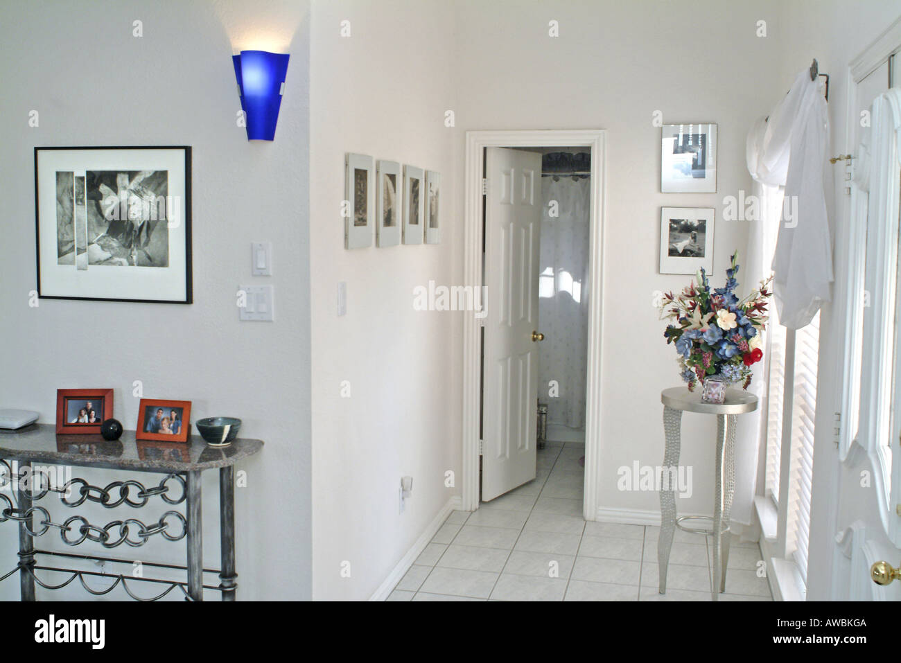 View of a hallway adorned with photo frames and flowers Stock Photo