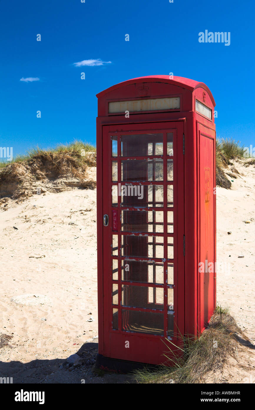 Traditional red British telephone box amongst the sand dunes of Studland Bay, Dorset Stock Photo