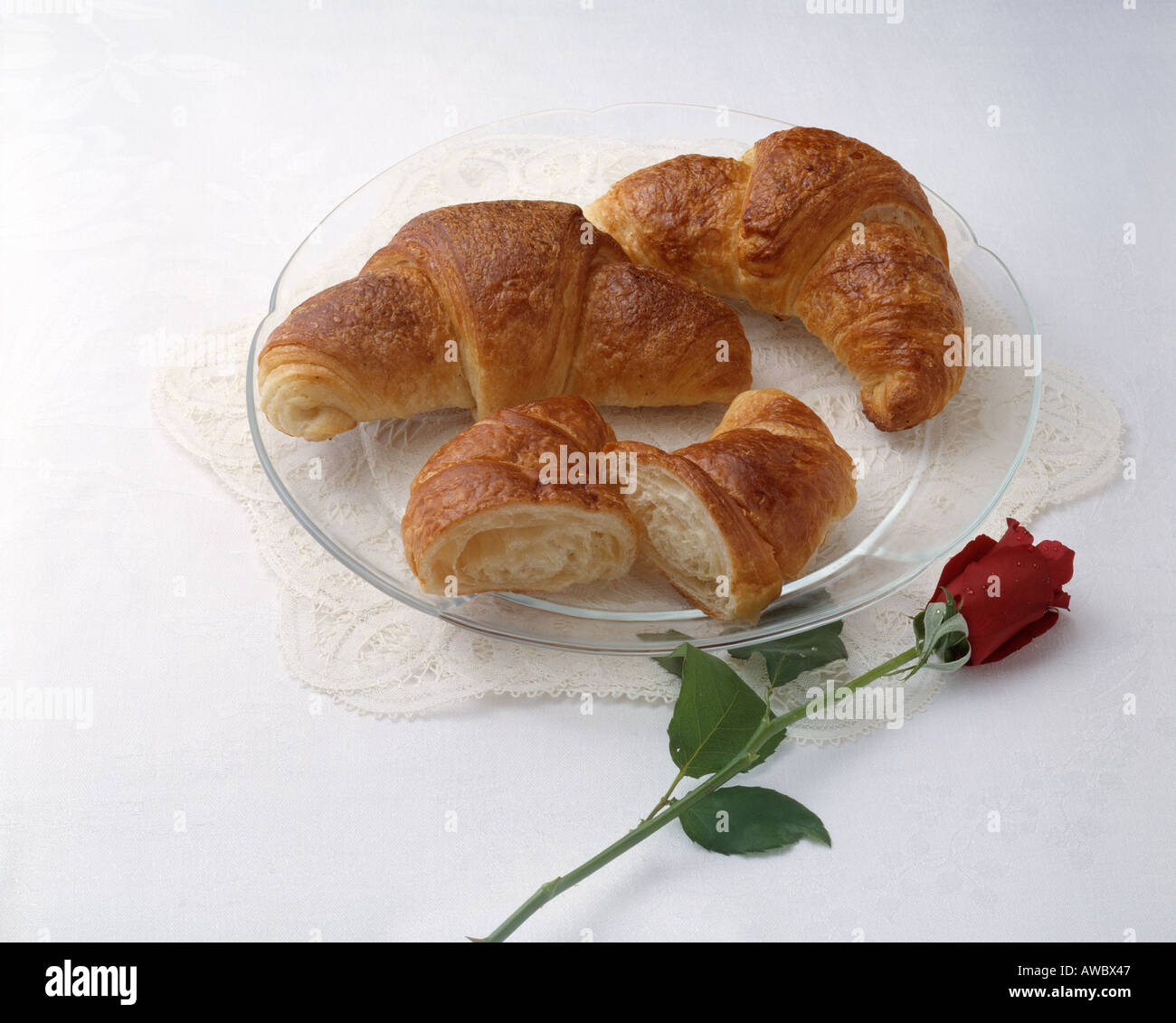 fast food hearty breakfast croissant glass plate long stem rose cuisine Stock Photo