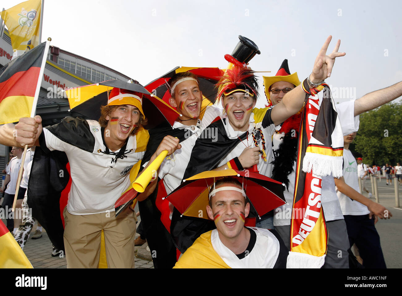 Male German supporters wearing umbrella hats cheer in the streets during the 2006 World Cup Stock Photo