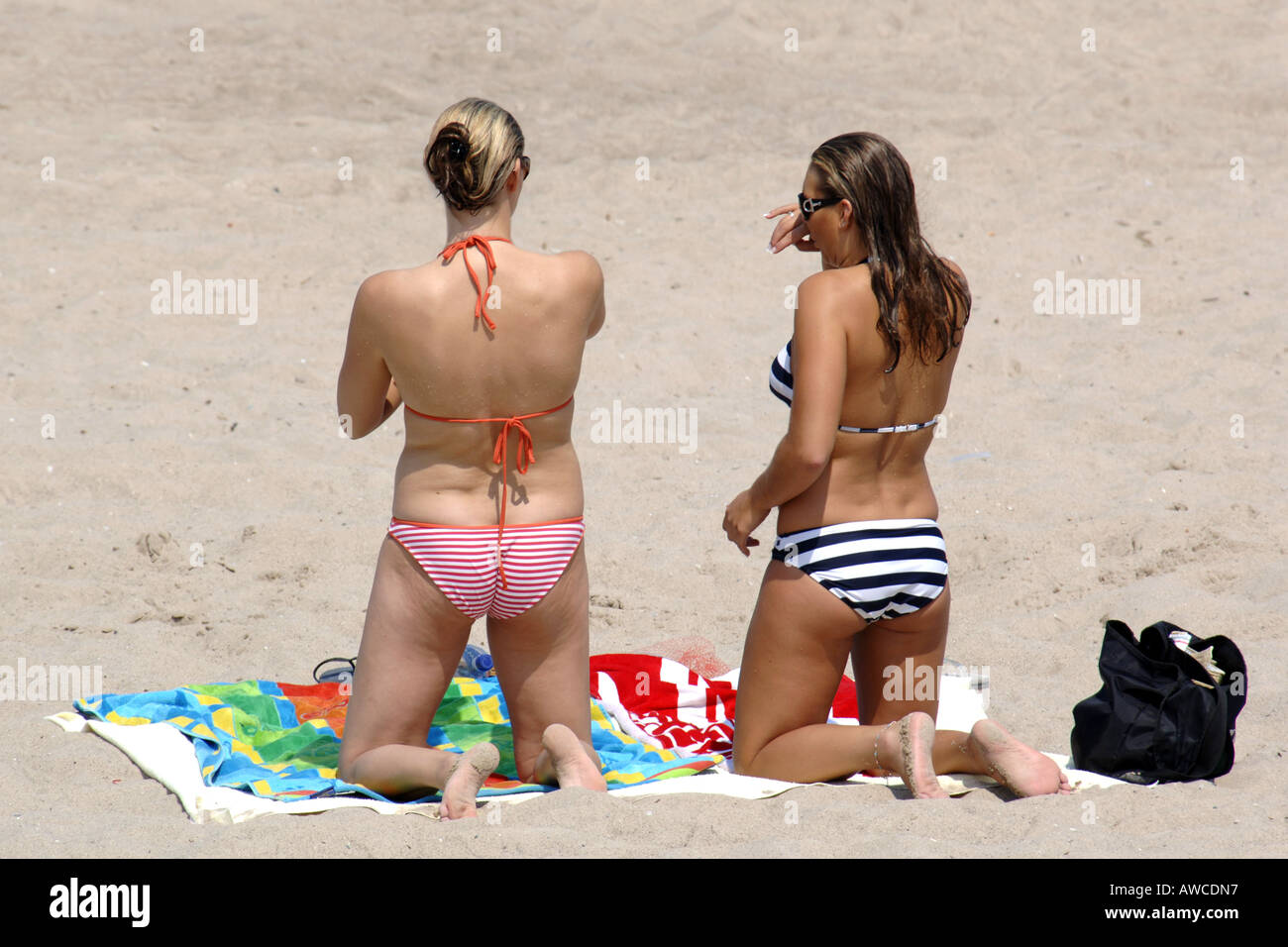 College girls on vacation the beach applying suntan lotion to their bodies  Stock Photo - Alamy