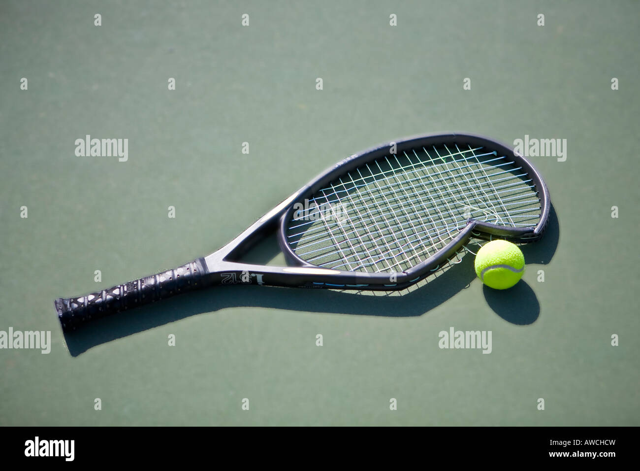 Broken tennis racket on green court with tennis ball Stock Photo Alamy