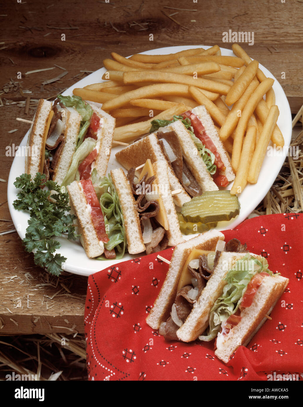 club sandwich roast beef toast cheese tomato pickle slice white plate lettuce french fry fries fast food Bon Appetit Stock Photo