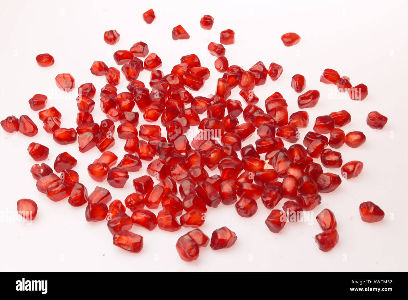 Pomegranate fruit red seeds scattered on white background Stock Photo Alamy