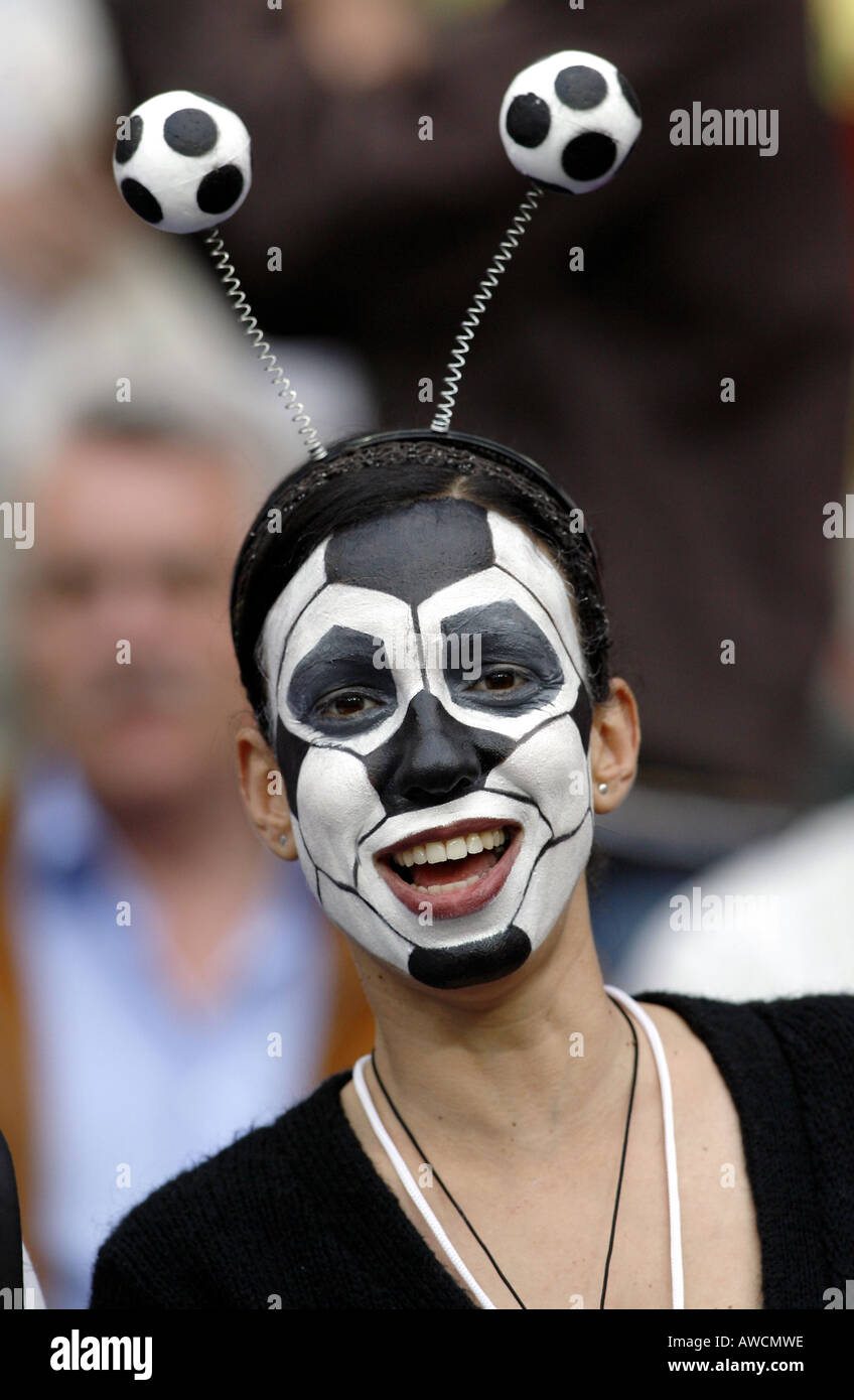 A supporter with a face painted as a football in the crowd during the 2006 World Cup Stock Photo
