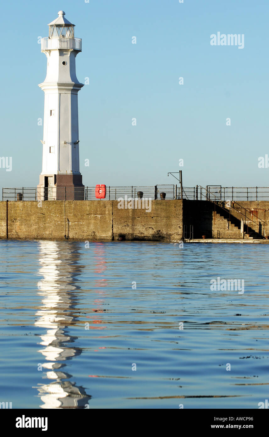 Old White cast-iron Lighthouse on harbour wall on a bright sunny day ...