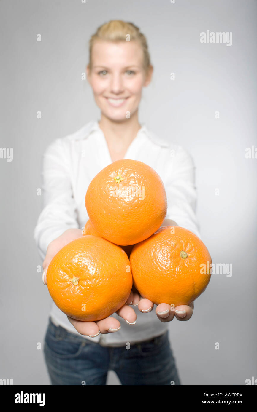 Blonde woman laughingly holding orange Stock Photo - Alamy
