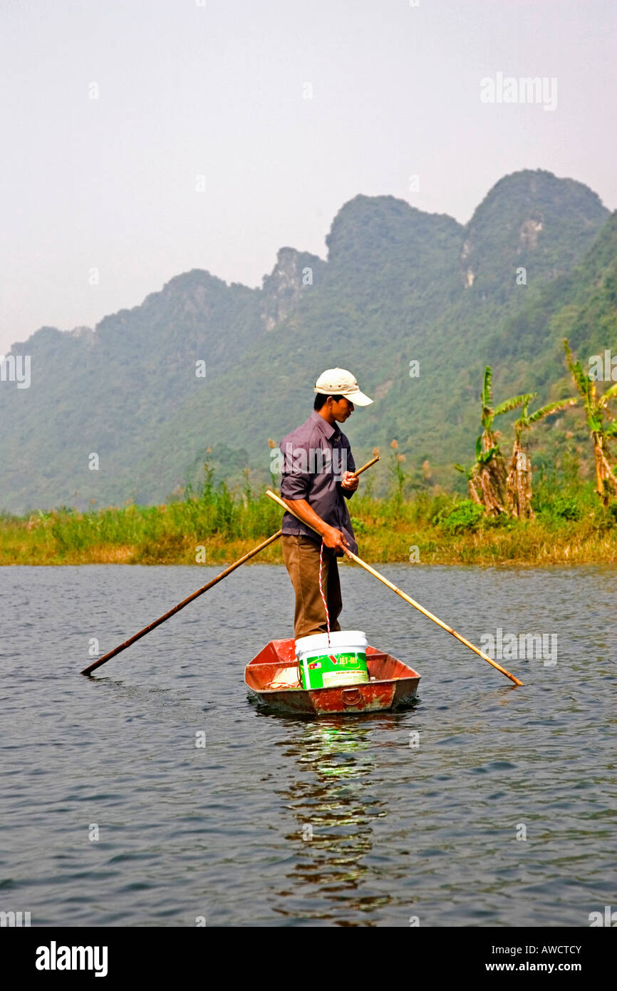 Vietnamese man fishing from his rowboat, Vietnam, Southeast Asia, Asia Stock Photo