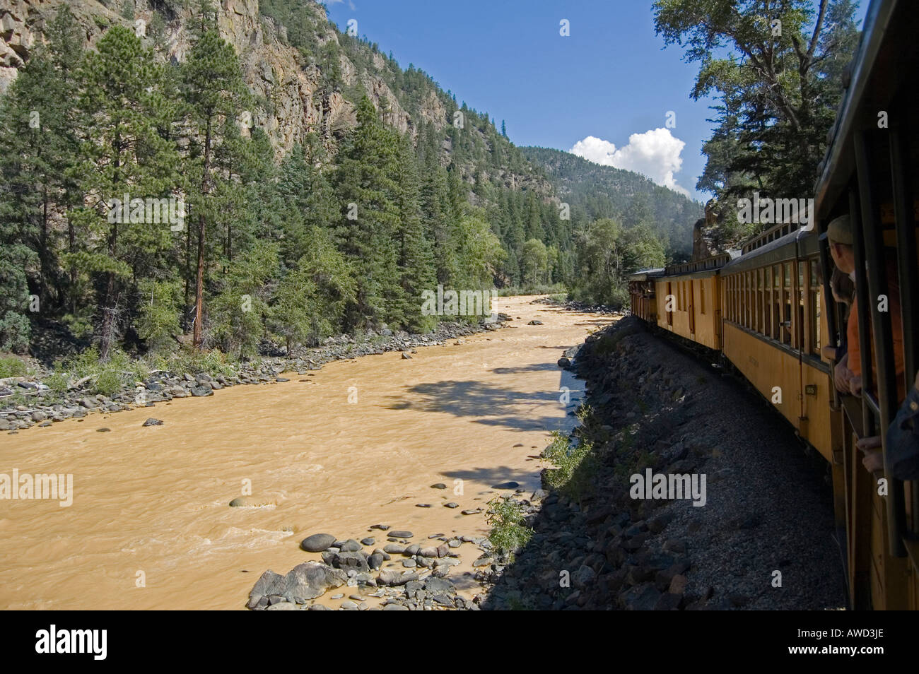 Railroad Train along River in Mountains Stock Photo