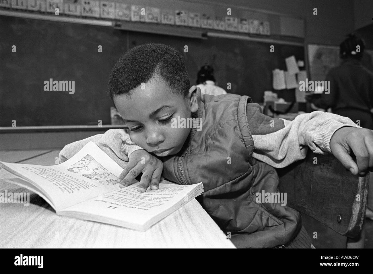 Elementary school child immersed in a book in the classroom Stock Photo