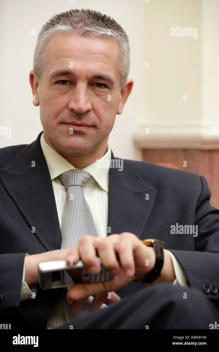Portrait of businessman holding mobile phone Stock Photo - Alamy