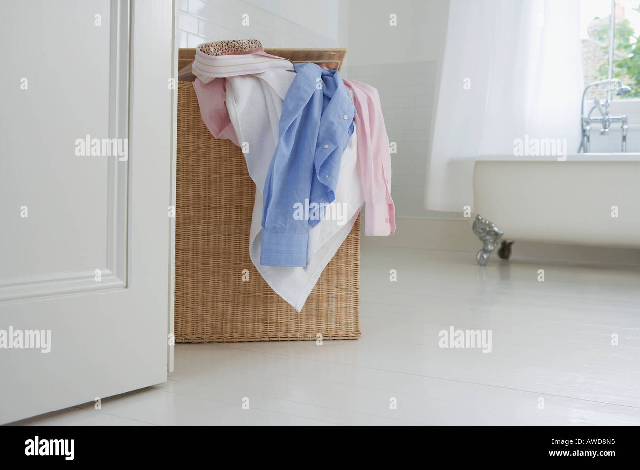 Overflowing laundry basket in bathroom Stock Photo Alamy