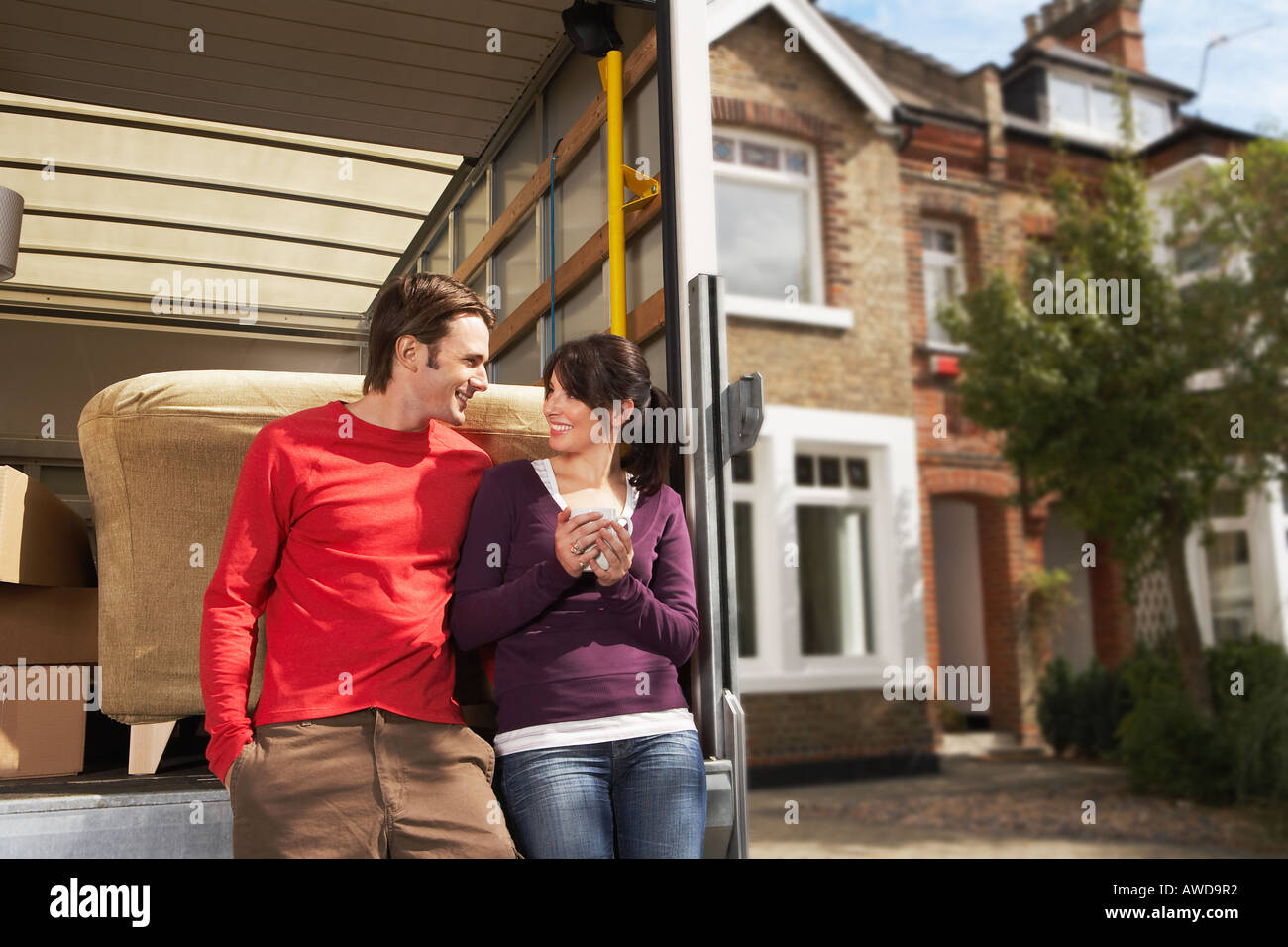 Couple Leaning On Back of Removals Van Stock Photo