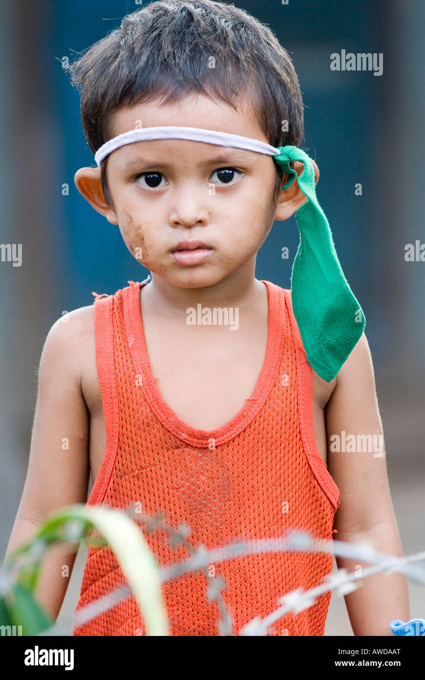 Boy dressed as indian playing between barbed wire in a slum. The inhabitants are being threatened by forced resettlement, Dey K Stock Photo