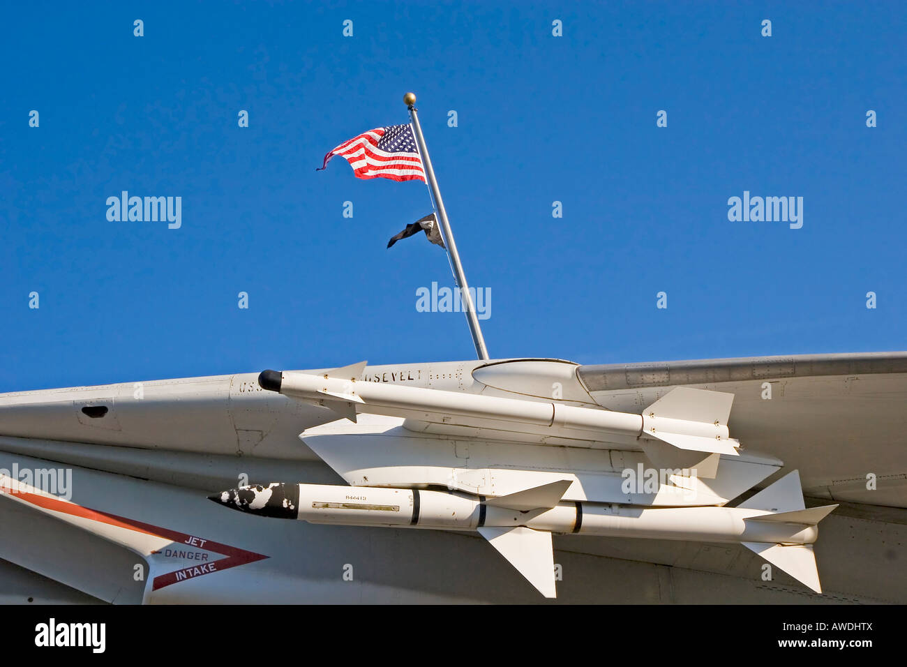 Missles under the wing of a fighter jet against blue sky with American flag and POW flag in background Stock Photo