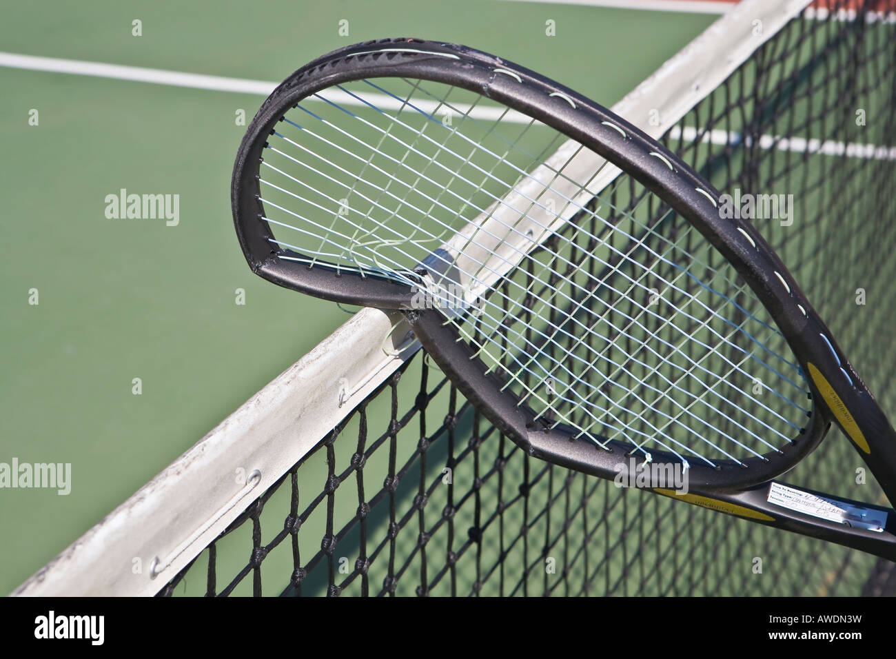 broken tennis racket resting on net cord Stock Photo Alamy