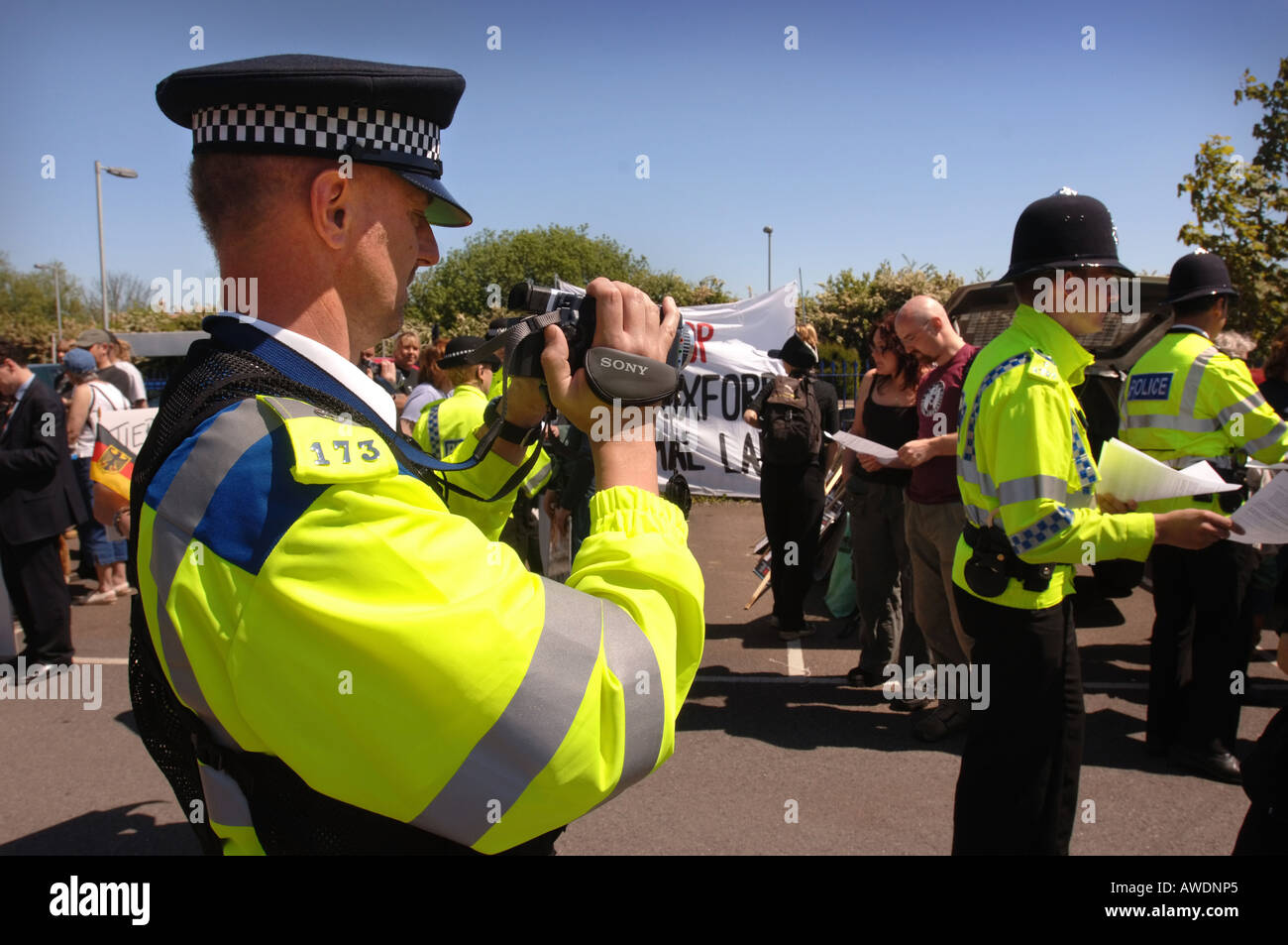 A POLICEMAN VIDEOING PROTESTERS AT AN ANIMAL RIGHTS MARCH IN MORETON IN MARSH GLOUCESTERSHIRE UK Stock Photo