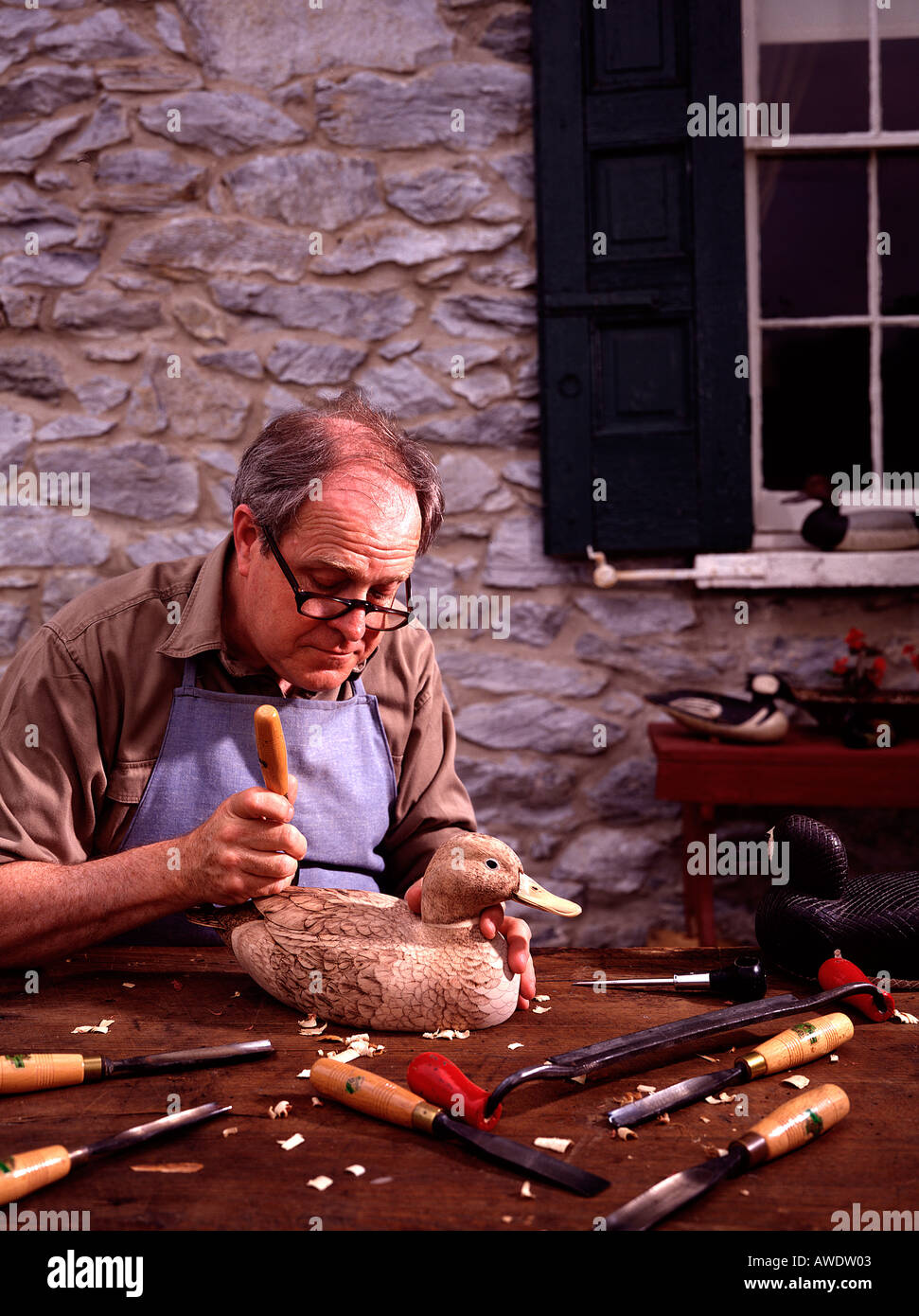 senior citizen retired wood carver carving wooden duck decoy chisel