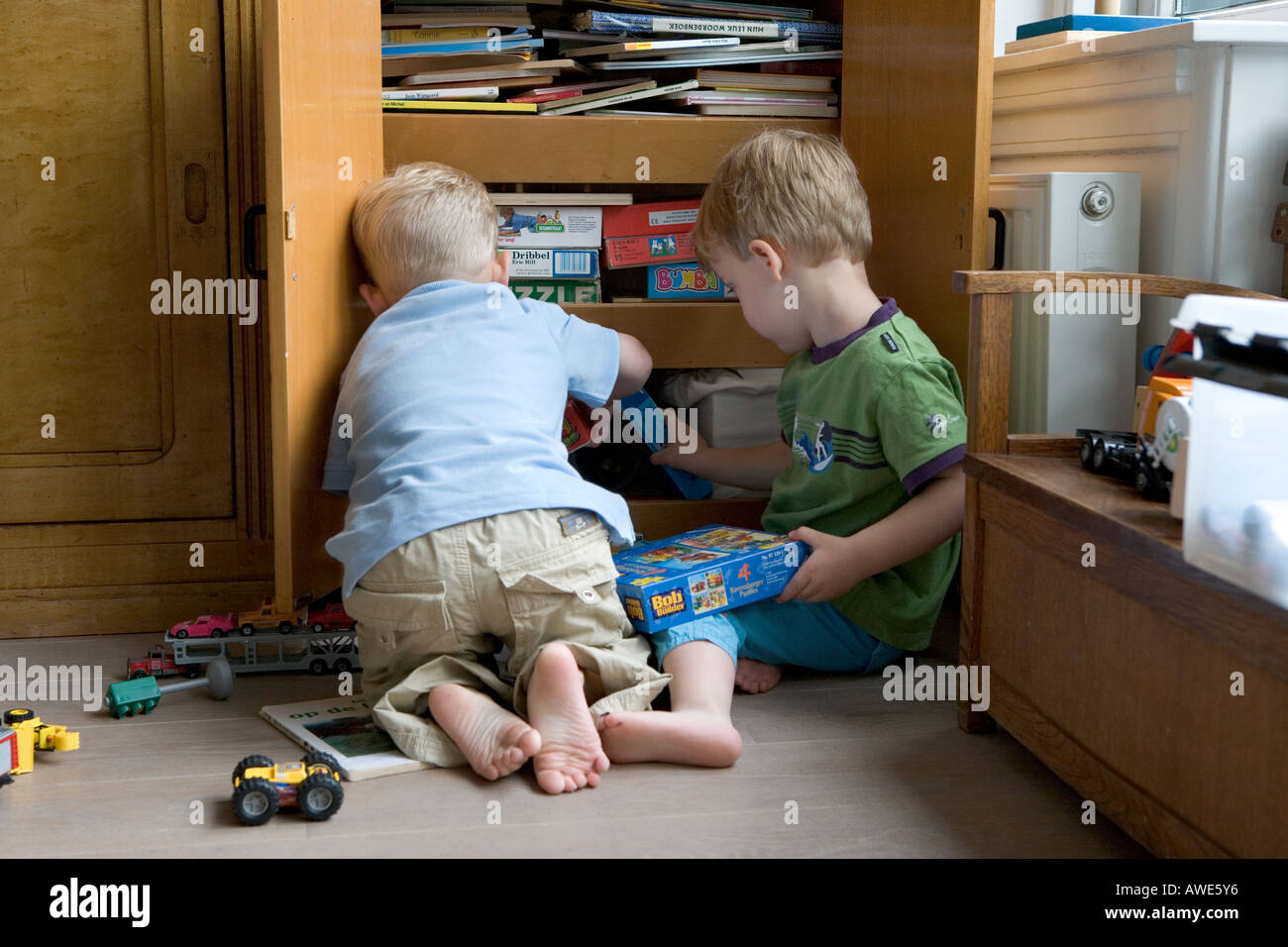 Two boys in front of a toy cupboard Stock Photo Alamy