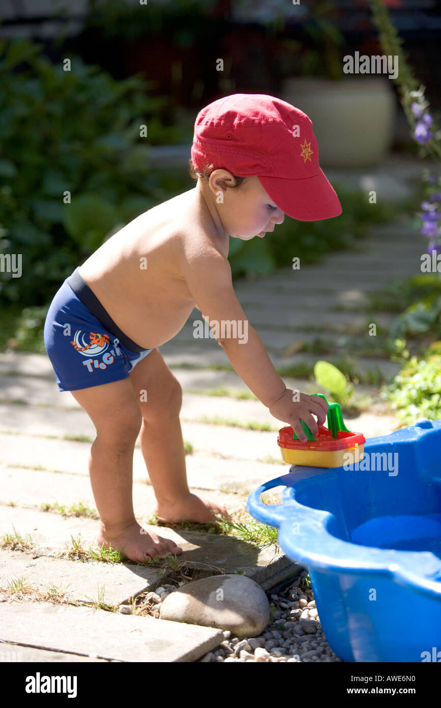 Little boy with a toy boat in the garden Stock Photo