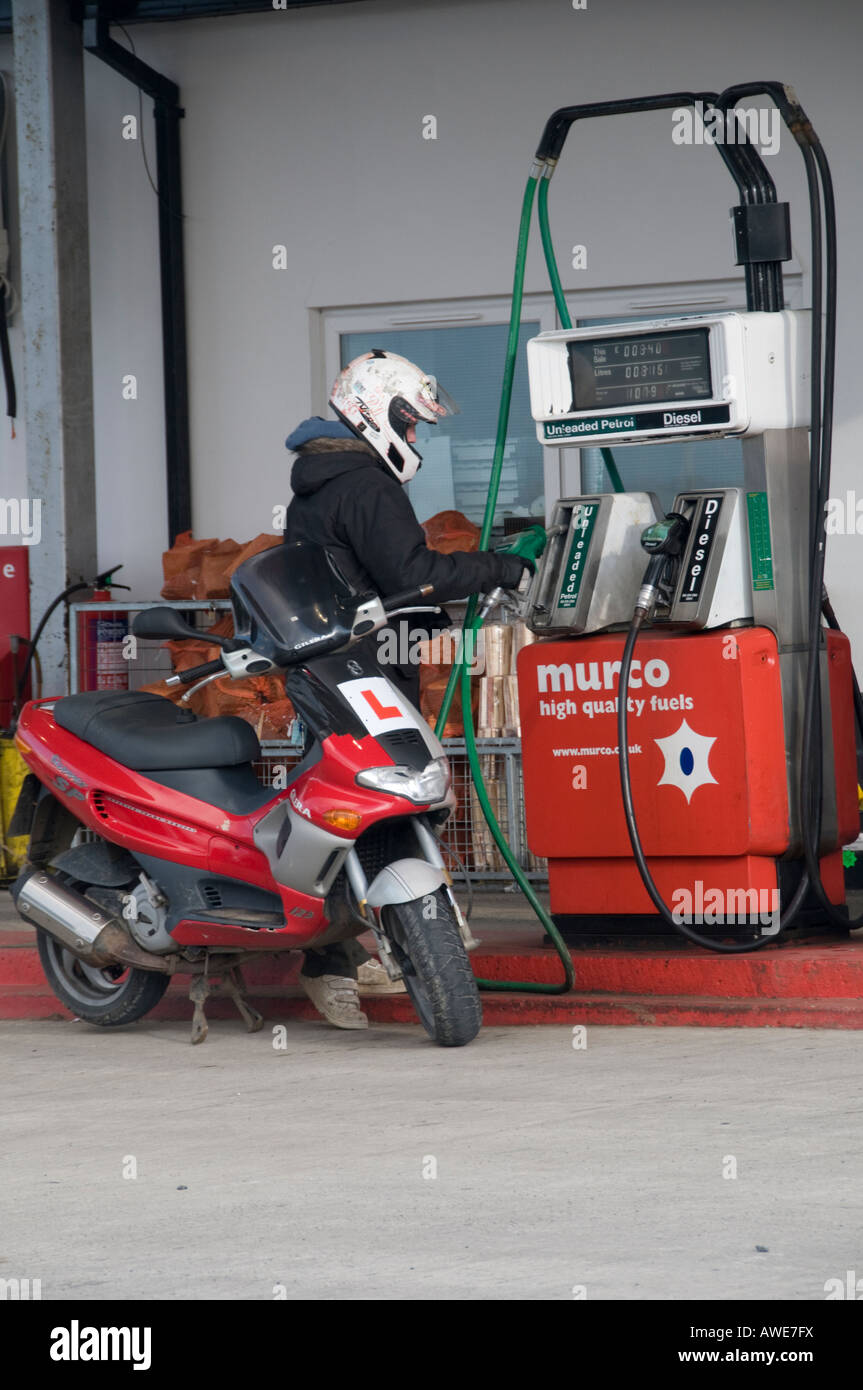 Motor scooter rider filling up tank with unleaded fuel at a Murco garage Stock Photo