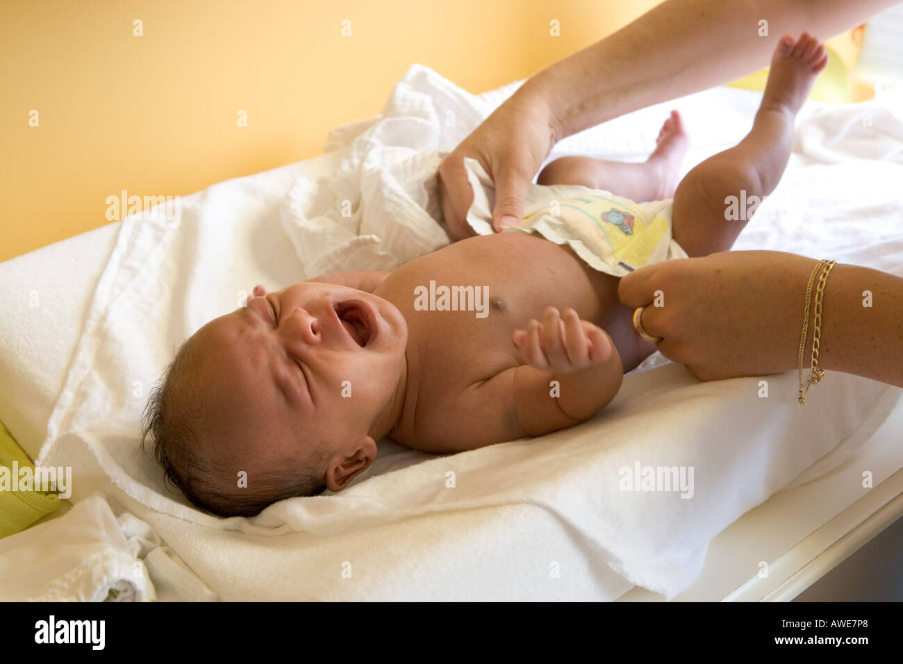 Mother is dressing her baby Stock Photo
