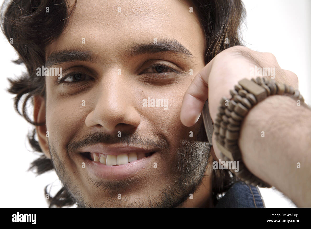 ANG200411 Teenage boy with beard and moustaches talking on mobile and smiling MR 687T Stock Photo