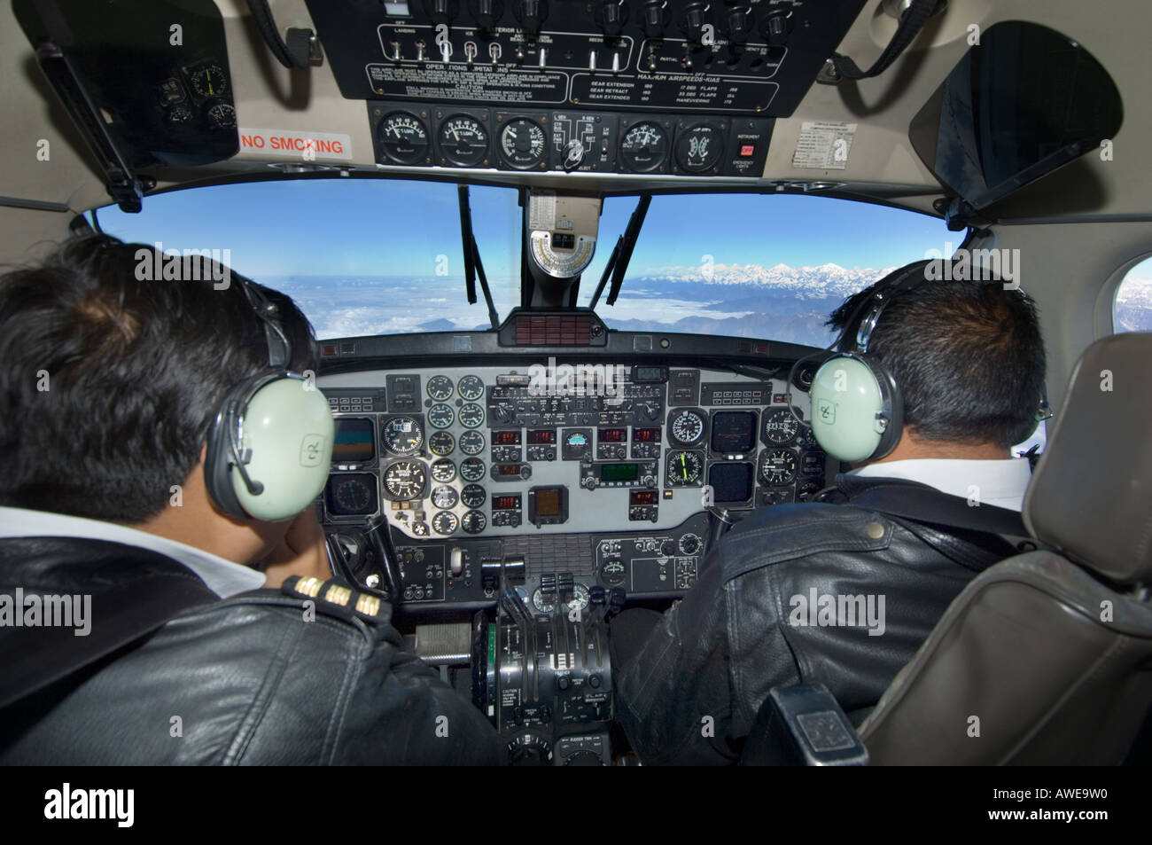 in the cockpit of an airplane plane captain and pilot flying over the himalayan mountain range Kathmandu NEPAL ASIA Stock Photo