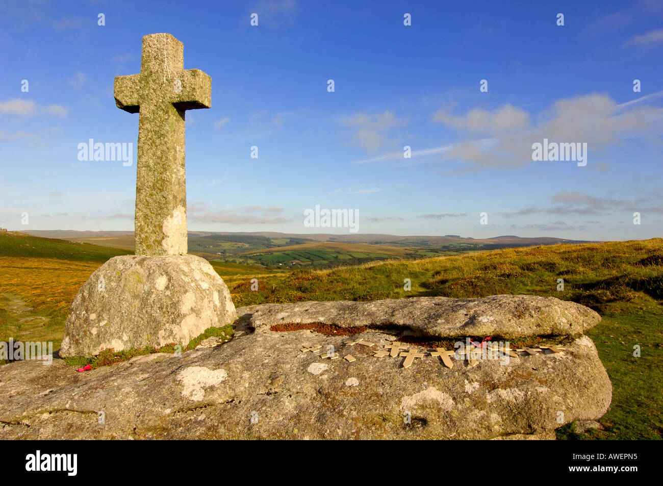 Granite cross on Dartmoor in beautiful golden summer evening light with blue sky and white clouds Stock Photo
