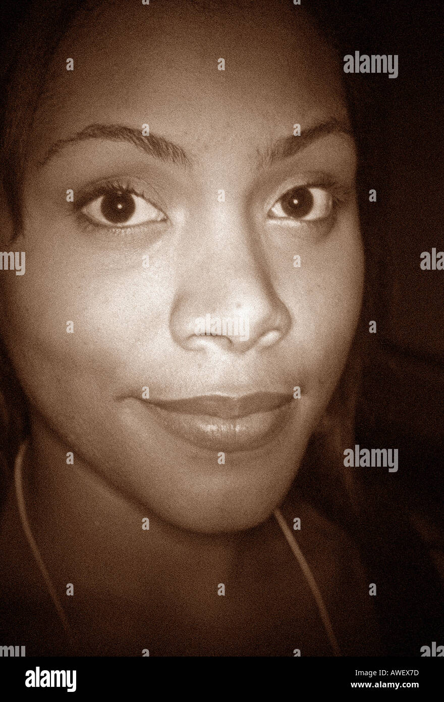 Sepia Brown Toned Spot Lit Closeup Portrait of a Woman of African and Hispanic Ethnicity Stock Photo