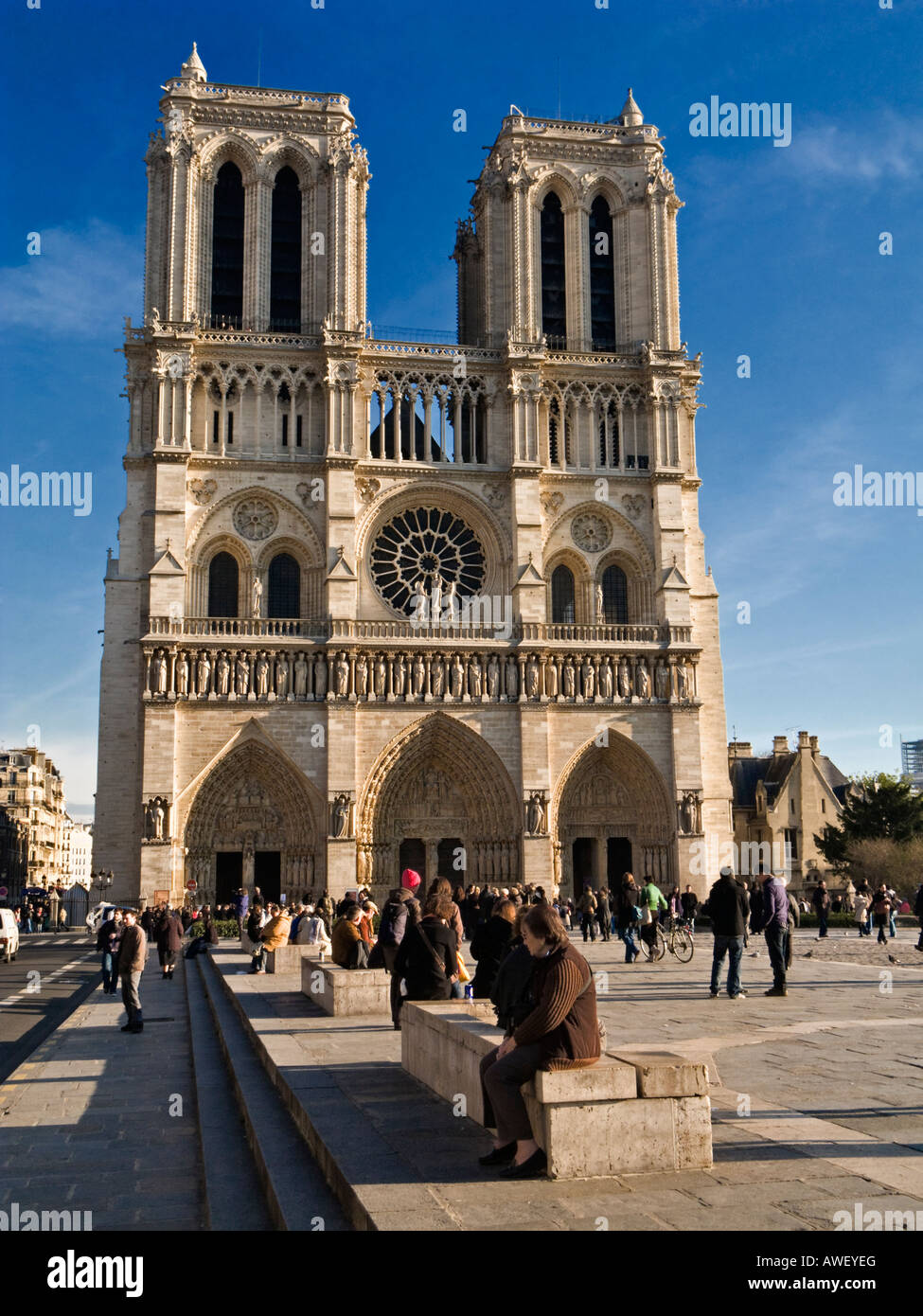 Notre Dame - Tourists sightseeing and sitting outside at Notre Dame Cathedral, Paris, France Stock Photo