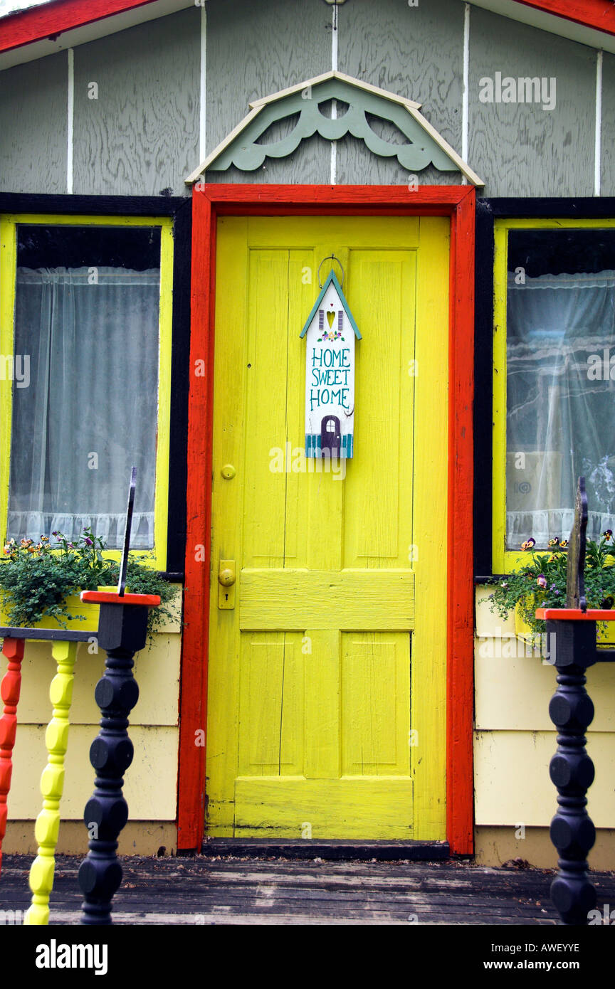 A bright yellow door and Home Sweet Home sign in Waldheim Saskatchewan Canada Stock Photo