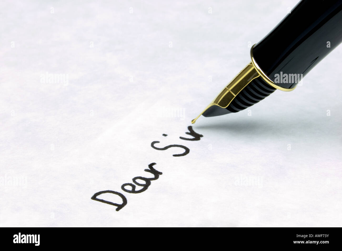 Dear Sir written on watermarked textured paper using a gold nibbed fountain pen Focal point is on the text Stock Photo