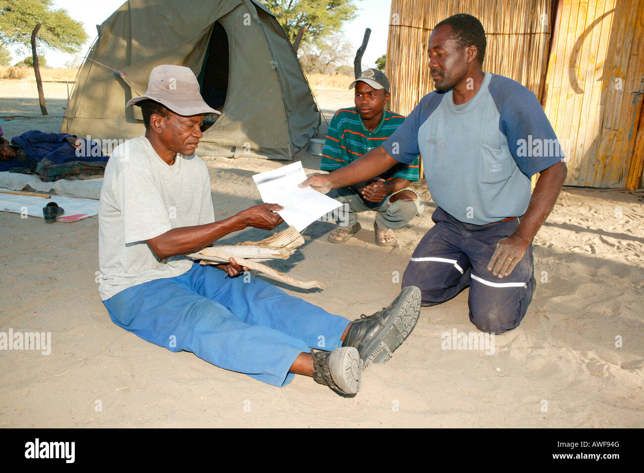 Traditional healer's patient being given his 'prescription' for medicinal herbs, Sehitwa, Botswana, Africa Stock Photo