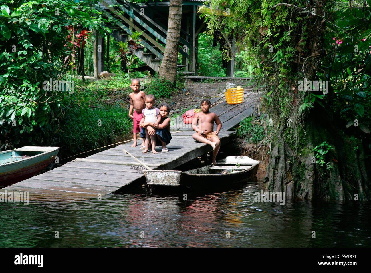 Children at a boat jetty, Kamuni river in the rain forest of Guayana, South America Stock Photo