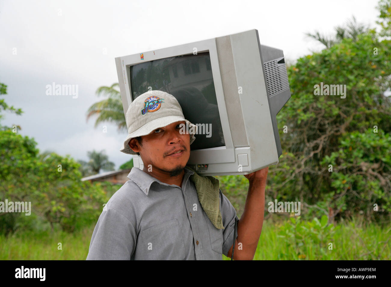 Man carrying television set to his house, Arawak native, Santa Mission, Guyana, South America Stock Photo