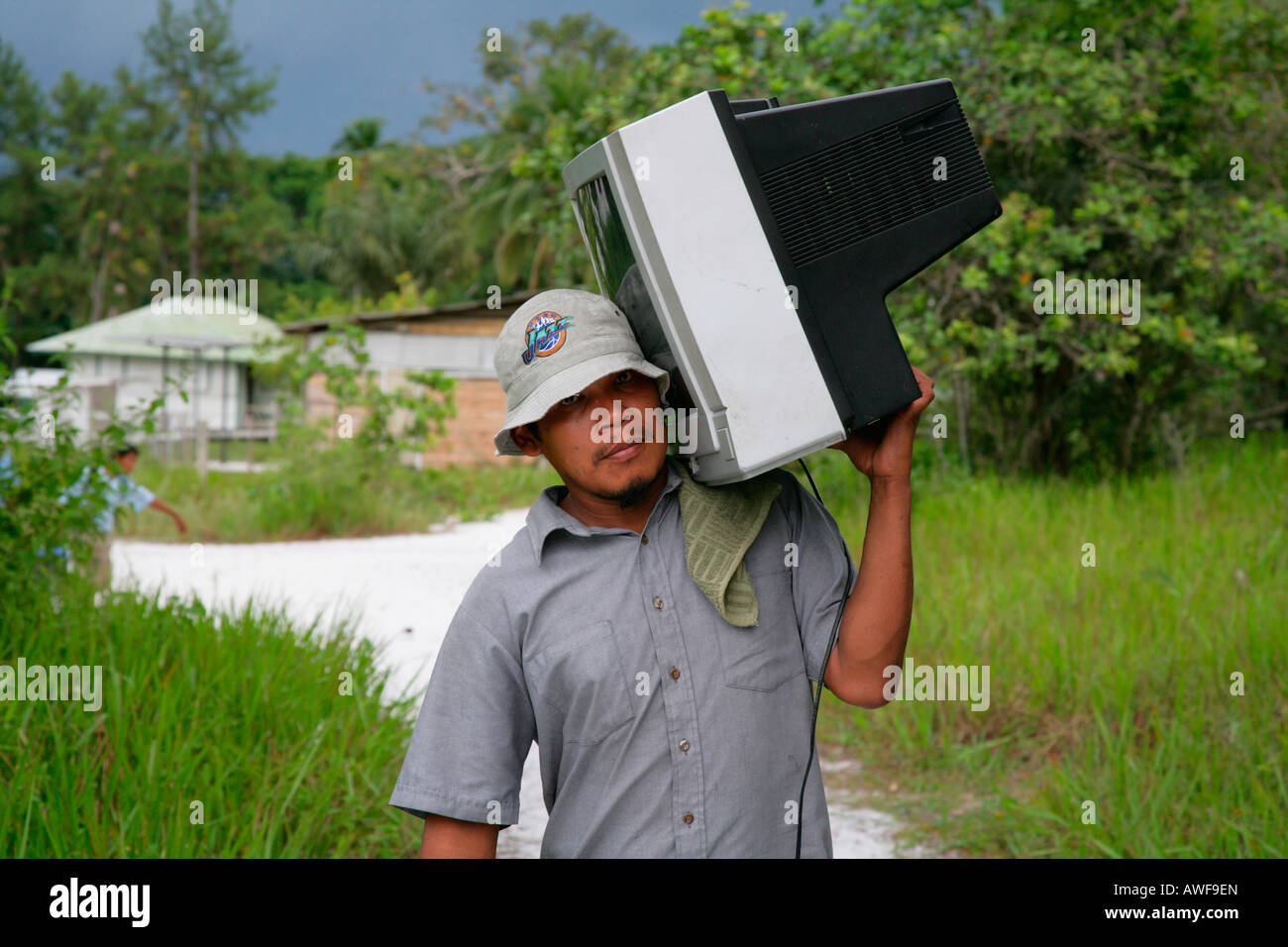 Man carrying television set to his house, Arawak native, Santa Mission, Guyana, South America Stock Photo