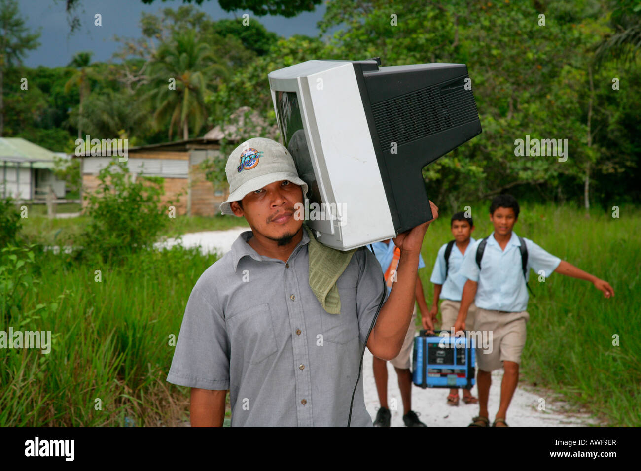 Man carrying television set to his house, Arawak native, Santa Mission, Guyana, South America Stock Photo