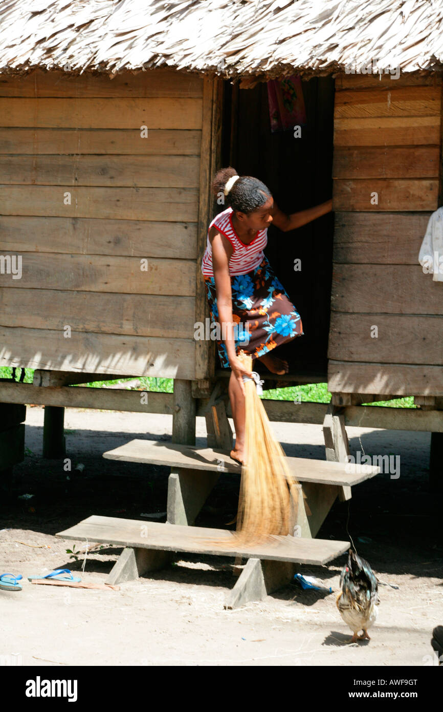 Young woman sweeping in front of the house, Amerindians of the Arawak tribe, Santa Mission, Guyana, South America Stock Photo