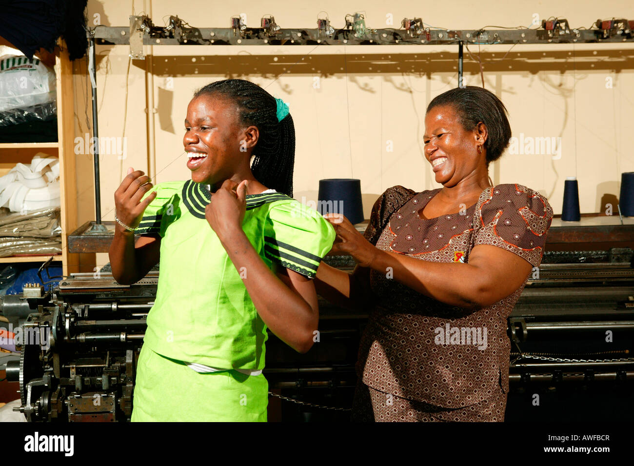 Women trying on a dress at a tailor's shop of an HIV/AIDS aid organization, Gaborone, Botswana, Africa Stock Photo