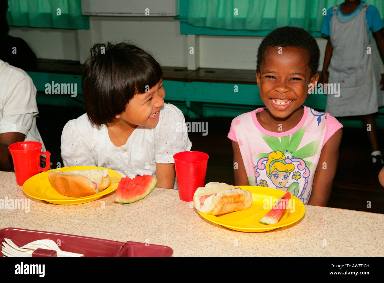 Two girls with full plates, everyday life at an Ursuline convent and orphanage, Georgetown, Guyana, South America Stock Photo