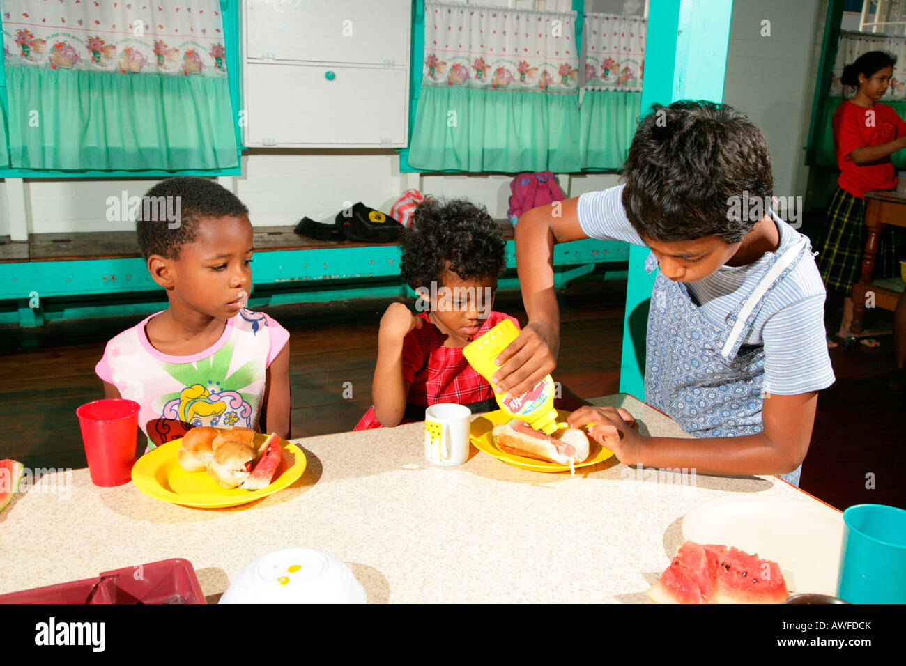 Girls with full plates, everyday life at an Ursuline convent and orphanage, Georgetown, Guyana, South America Stock Photo