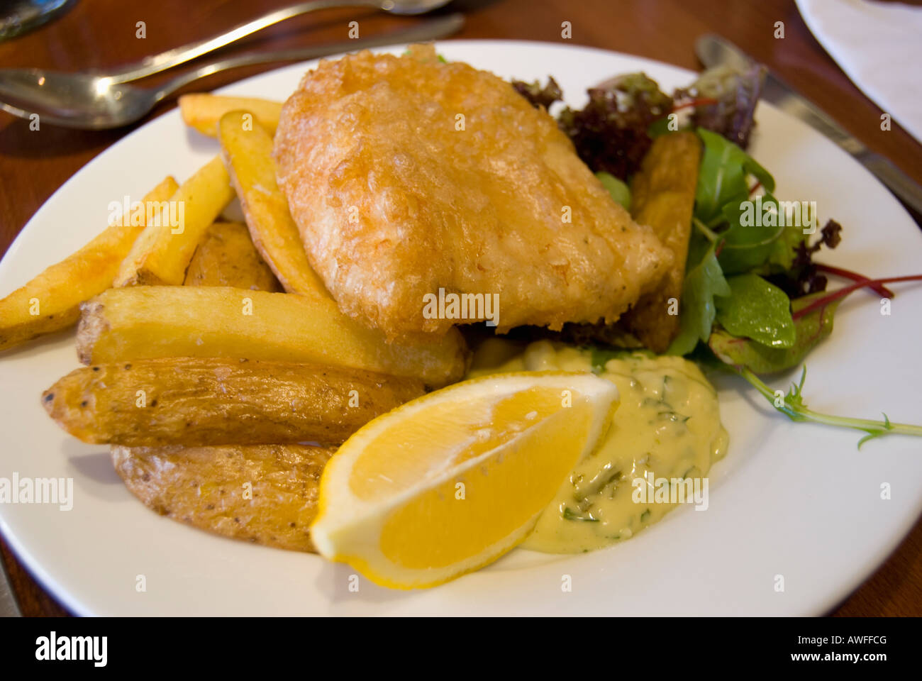Fish and Chips, battered cod and deep fried potatos served in a restaurant in Edinburgh, Scotland. Stock Photo